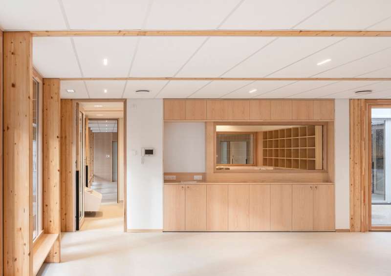 Vue sur les espaces de changement des enfants, équipements de mobilier en bois, alliant fonctionnalité, confort et esthétique naturelle.