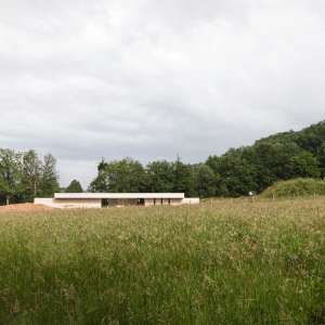 Façade principale de la crèche d'Espalion, réalisée en béton damé, mettant en valeur une architecture sobre et durable intégrée à son environnement