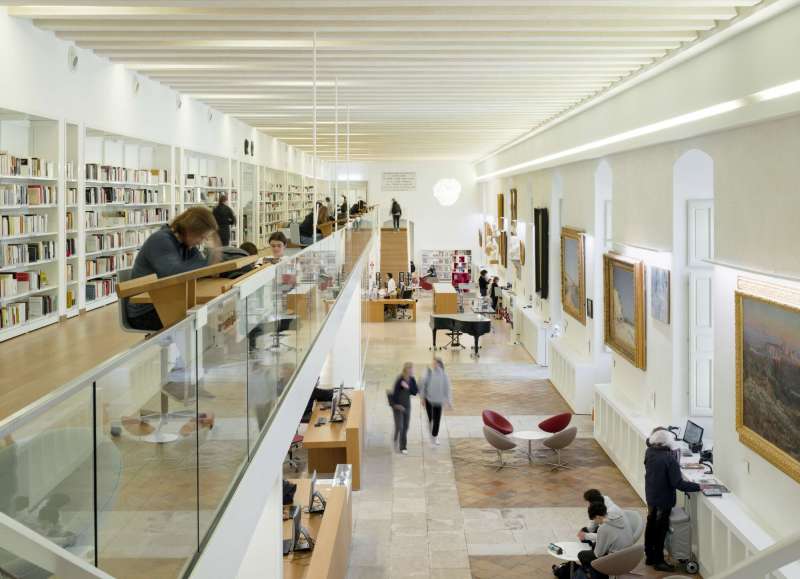 Vue intérieure de la bibliothèque de l'Inguimbertine, dévoilant la mezzanine élégante et l'agencement harmonieux des espaces de lecture et de circulation